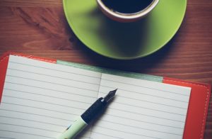 notepad, pen, and coffee cup