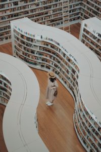 image of a person standing surrounded by library shelves