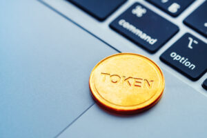 Text Token written on a golden coin lying on the modern laptop.
